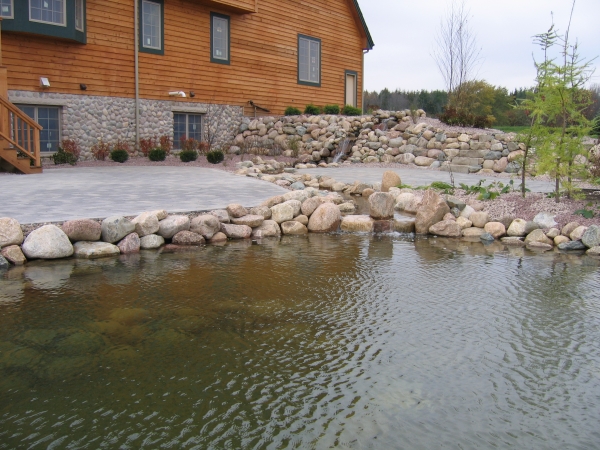 Concrete patio, outdoor pond and stone retaining wall installed in Wisconsin